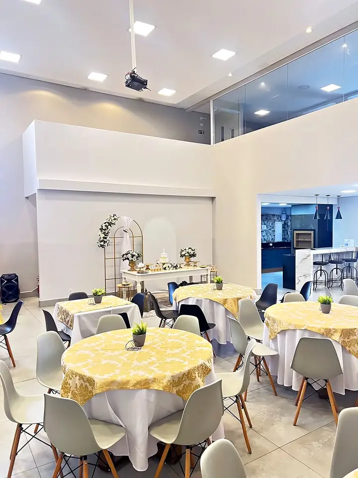 Salão principal com mesas redondas e toalhas douradas
